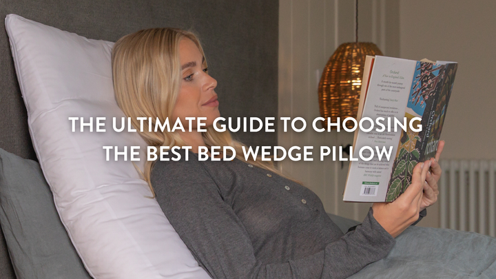 Person sitting up in bed supported by a British Wool Bed Wedge Pillow 